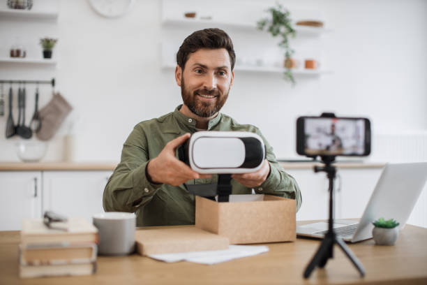 istock Man showing VR glasses while recording video on mobile 1748017923
