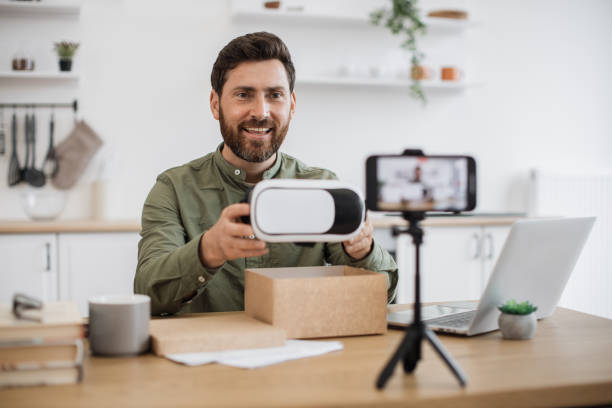 istock Man showing VR glasses while recording video on mobile 1748017927