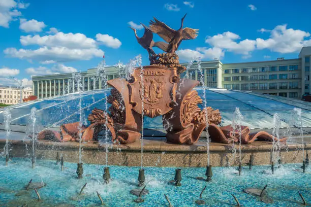 Sculpture of cranes fountain in Independence Square against the background of a blue sky with clouds Minsk , Belarus.