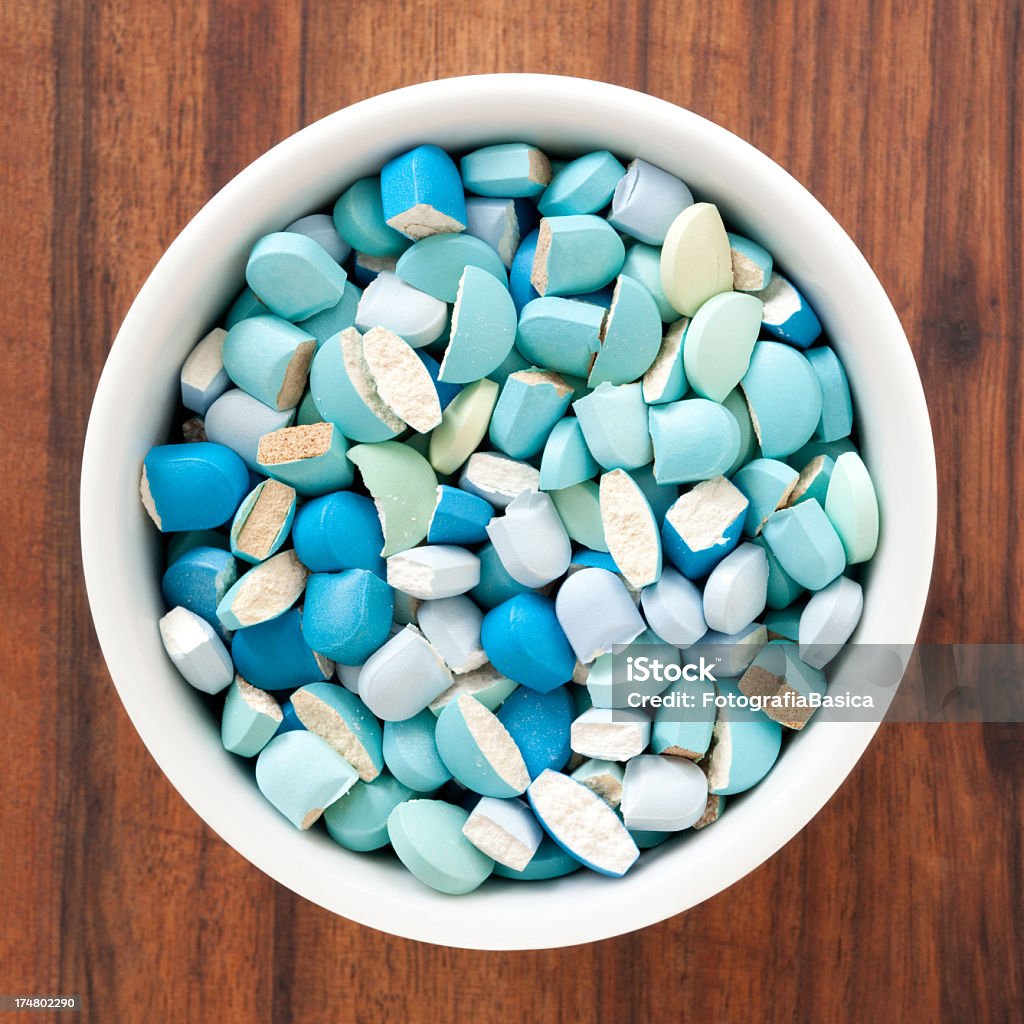 Broken blue pills Lots of broken blue pills in bowl Addiction Stock Photo