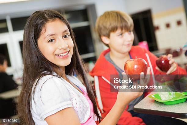 Grundschule Mädchen Essen Ein Gesundes Mittagessen In Der Cafeteria Serviert Stockfoto und mehr Bilder von Essen - Mund benutzen