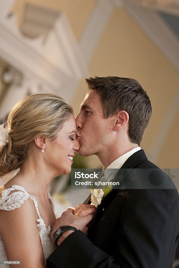 Romantico sposi è Baciare la sua bella sposa nella Hall della Reception - Foto stock royalty-free di Abbracciare una persona