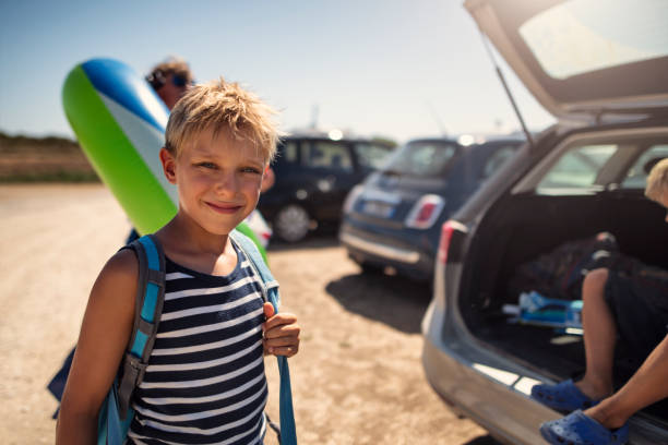 istock Happy boy unpacking car and going on to the beach 1748032993