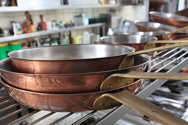 plano aproximado de cobre fryingpans empilhados em uma cozinha profissional - kupferpfanne imagens e fotografias de stock