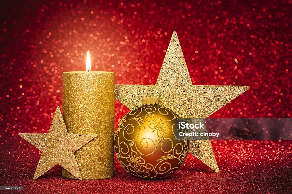 Xmas Star Golden Christmas stars with candle and christmas ornament on red glitter background. Advent Stock Photo