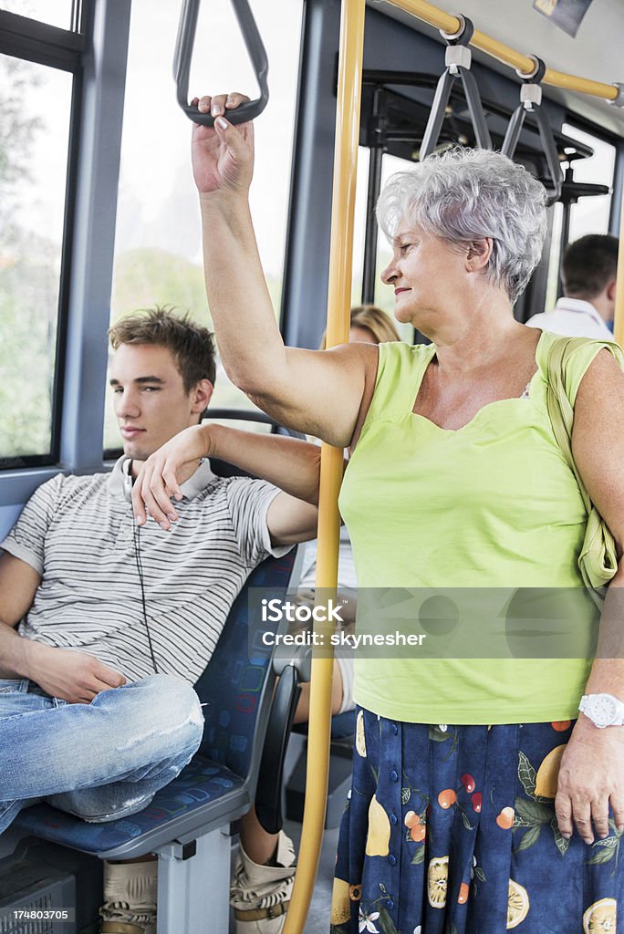 Старший женщина, глядя на молодой человек, сидя в автобусе. - Стоковые фото Автобус роялти-фри