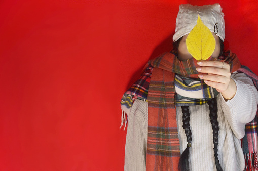 Woman Holding Autumn Colored Leaf/Studio Shot