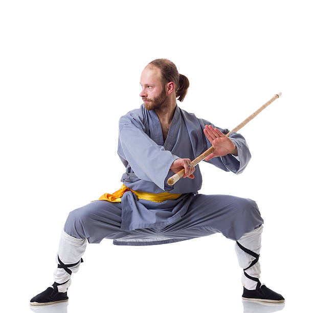 kung fu fighting posizione con wushu cudgel isolato su bianco - self defense wushu action aggression foto e immagini stock