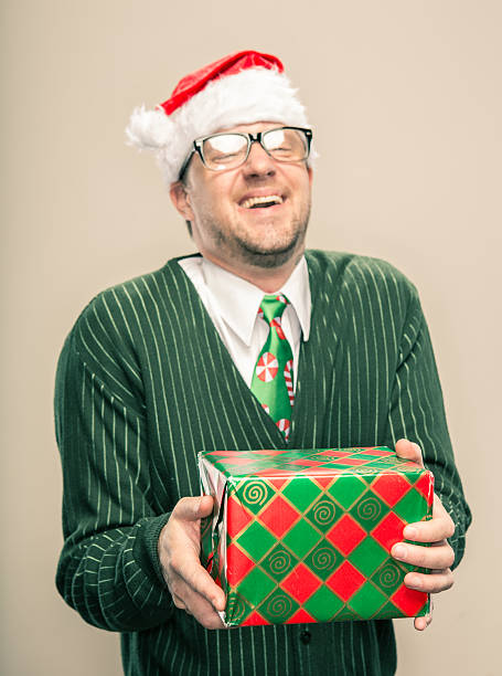 istock Joyful Nerdy Christmas Man holding wrapped holiday gift 174804369