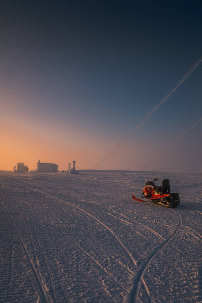 Backcountry snowmobiler rides across glacier through fresh powder snow, Whistler
