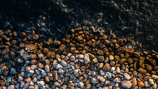 Waves crashing on seashore rocks,Top view sea surface waves background