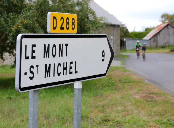 Photo of Road sign with arrow and directions to the Mont Saint Michel Abbey in France