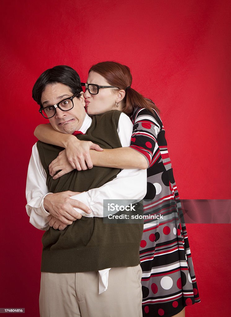 Nerdy Woman Attacking Nerd With An Awkward Kiss A scared nerdy man being attacked with a kiss from a nerdy woman. Couple - Relationship Stock Photo