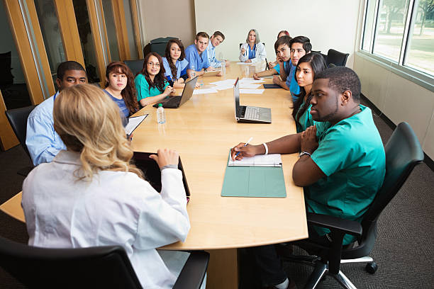 Hospital staff, doctors, & nurses having meeting in board room "Hospital staff, doctors, & nurses having meeting in board room" healthcare and medicine business hospital variation stock pictures, royalty-free photos & images