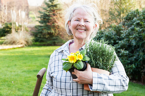 allegro donna anziana giardinaggio pronto per la primavera - women large build gardening outdoors foto e immagini stock