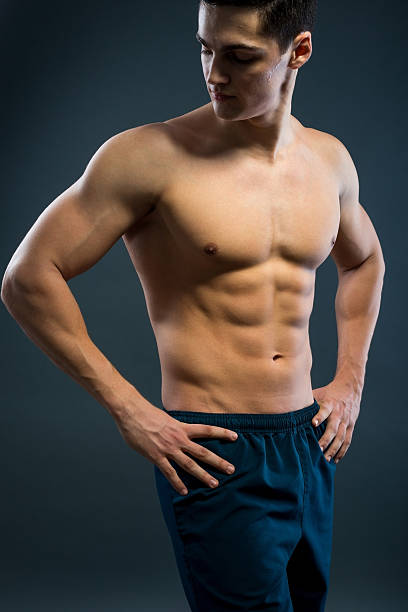 スポーティな若い男性、灰色の背景 - sex symbol the human body male abdomen ストックフォトと画像