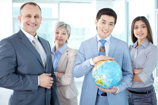 Group of business people with globe looking at camera
