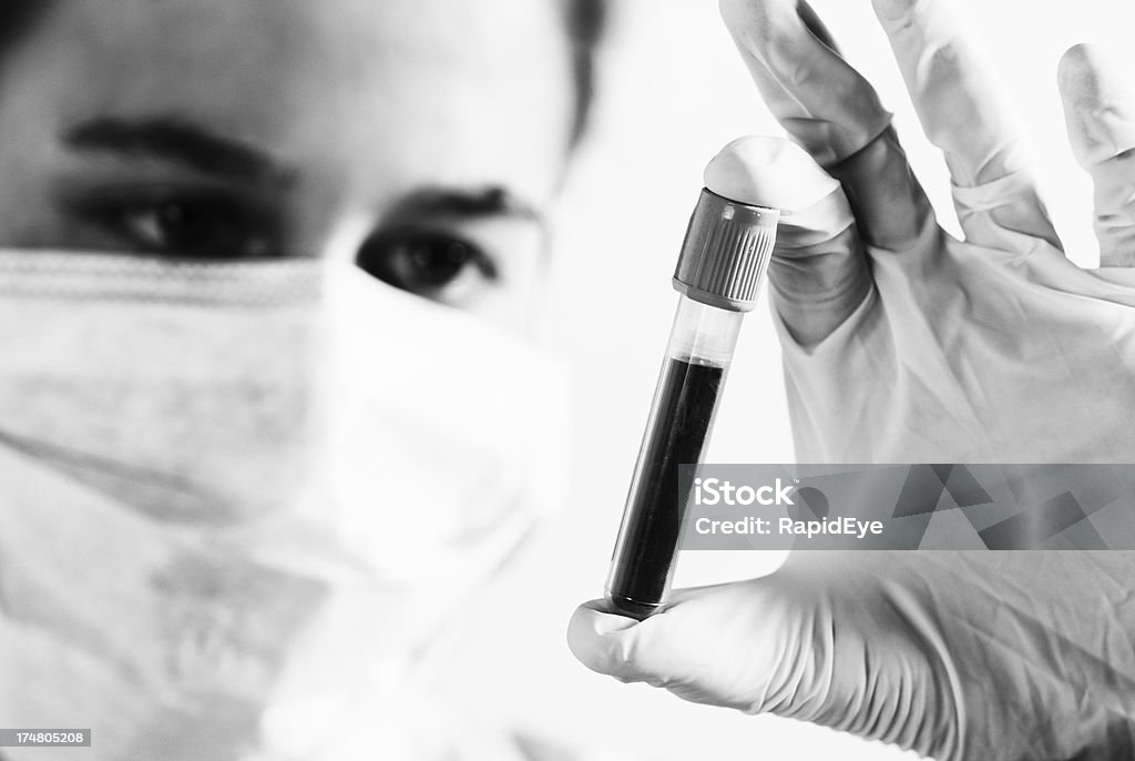 Ebola? Donna giovane Scienziato esaminando un campione di sangue con cautela - Foto stock royalty-free di Bianco e nero