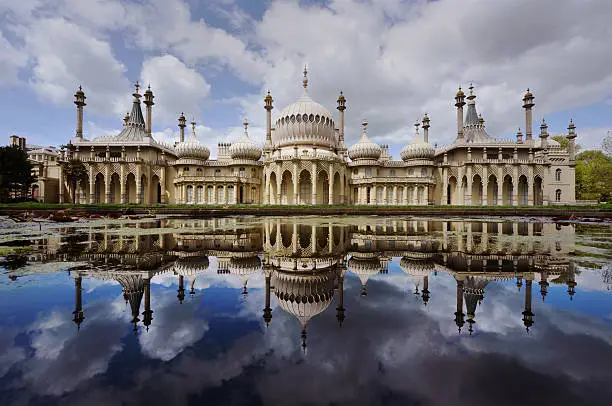 "The Brighton Pavilion reflected in an ornamental pondStraight wide-angle photograph - no image manipulationThe Royal Pavilion is a former royal residence (now a public building) located in Brighton, England. It was built in three stages, beginning in 1787, as a seaside retreat for George, Prince of Wales, from 1811 Prince Regent. It is often referred to as the Brighton Pavilion. with copy space"