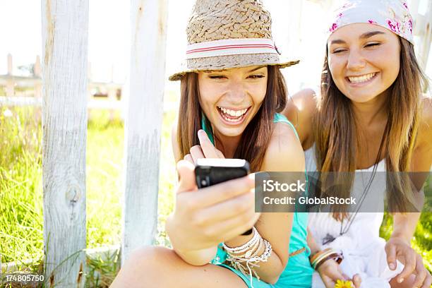 두 웃는 젊은 여자대표 루킹 At 스마트폰 20-29세에 대한 스톡 사진 및 기타 이미지 - 20-29세, 2명, 갈색 머리