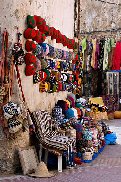 Marrakesh, Morocco - February 5, 2016: A local woman in a blue hijab sells pants outside the walls of Marrakesh’s Medina by Bab Doukkala.
