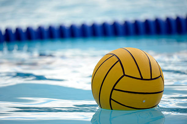 Water Polo Ball A yellow blue water polo balls rests in a water. water polo stock pictures, royalty-free photos & images