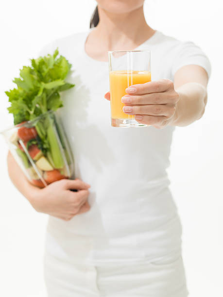 持つ女性オレンジジュース、野菜 juicer - freshnes ストックフォトと画像