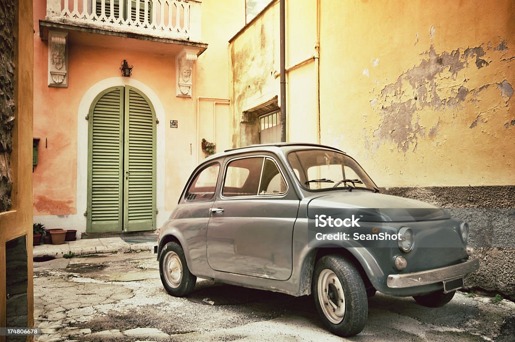 Old Mini Cooper in the alley of an Italian village Old Italian car. Aging process added. Old-fashioned Stock Photo
