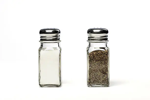 Photograph of a pair of salt and pepper shakers, isolated on white.