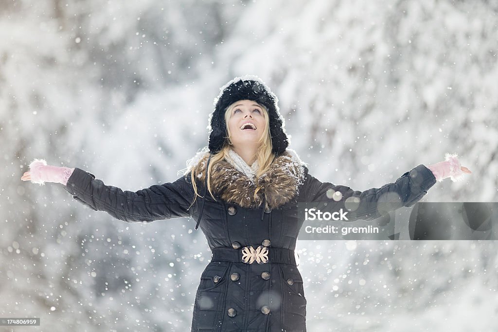 Giovane donna all'aperto in nevicata invernale giorno - Foto stock royalty-free di Abiti pesanti