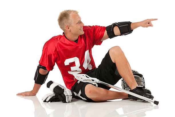 istock Lacrosse player sitting on the floor and pointing 174807558