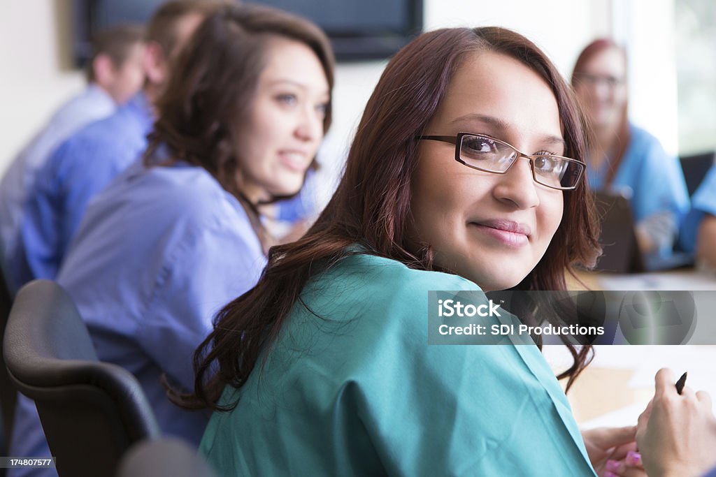Jovem Hispânico enfermeira Olhando para trás durante a reunião da Equipe médica - Royalty-free Profissional de enfermagem Foto de stock