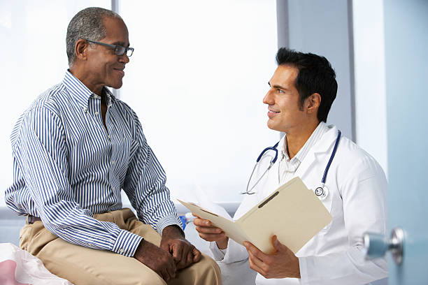 istock Doctor In Surgery With Male Patient Reading Notes 174807703