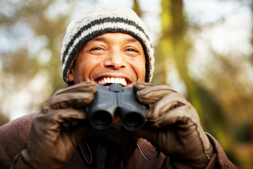Smiling mature man with binoculars - Outdoors