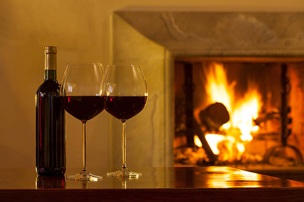 istock Red wine bottle and glasses with fireplace 174808006