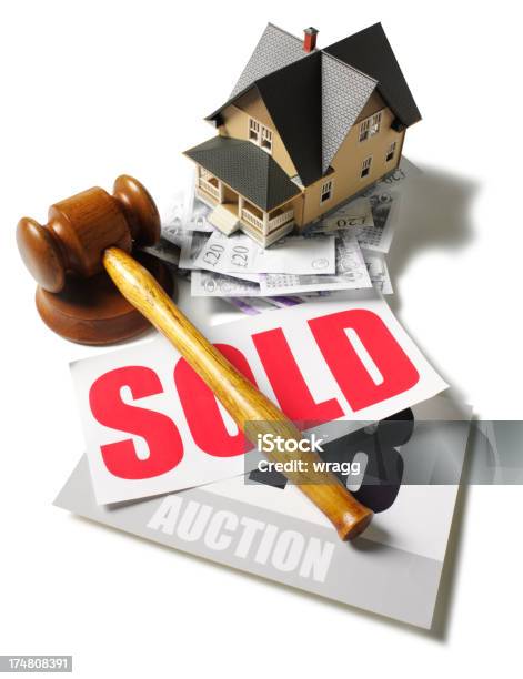 Toy House With British Pounds At An Auction Stock Photo - Download Image Now - Auction, Foreclosure, Auction Paddle