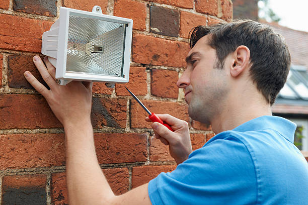 istock Man Fitting Security Light To Wall Of House 174808628