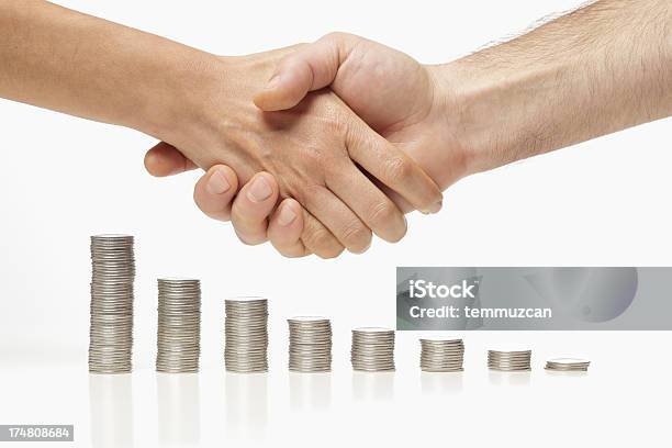 People Shaking Hands Over Stacked Coins Stock Photo - Download Image Now - Canadian Dollars, Holding, Two People