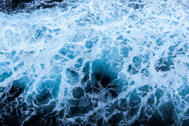 istock High angle view of a blue abstract background with sea foam design. Drone pointing view 1748093277