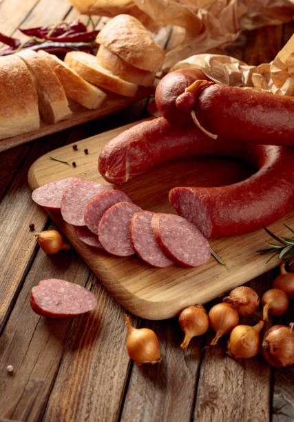 Smoked sausage with bread and spices on a old wooden table.