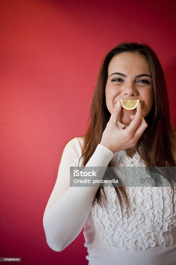 Lemon Smile Pretty smiling brunette holding a lemon slice. 20-24 Years Stock Photo