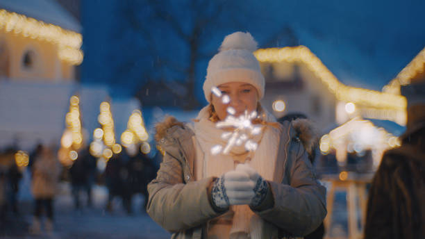 Woman holding sparkler on a cold winter at blue hour