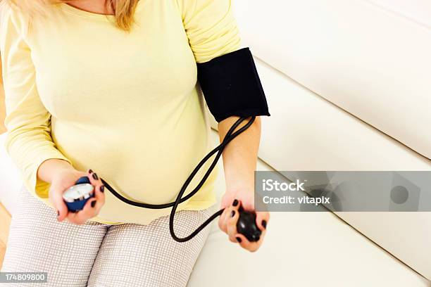 Pregnant Woman Measuring Blood Pressure At Home Stock Photo - Download Image Now - 30-39 Years, Abdomen, Adult