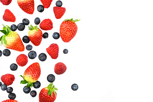 Many different berries in the form of a frame on a white background.