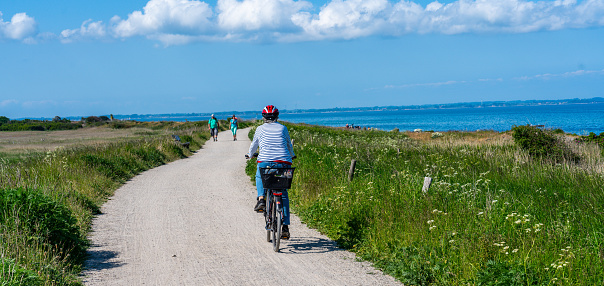 Baltic Sea, Germany, Jun 06, 2023:A woman riding bicycle at Baltic sea during summer.