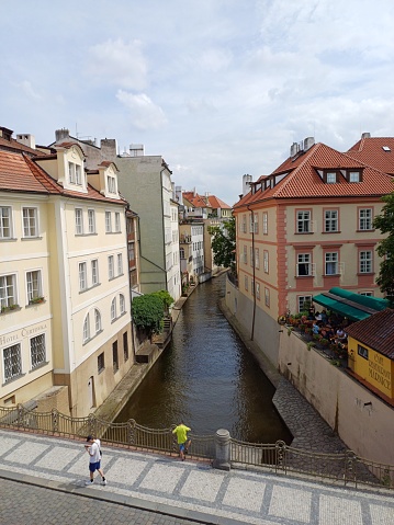 Prague, Czech Republic - June 9, 2023: A small river flows through Lesser Town in Prague city, Czech Republic. It is a section of Vltava river.