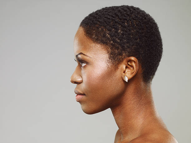 Attractive Young African Woman Side view portrait of an attractive young african woman with short hair. side view stock pictures, royalty-free photos & images