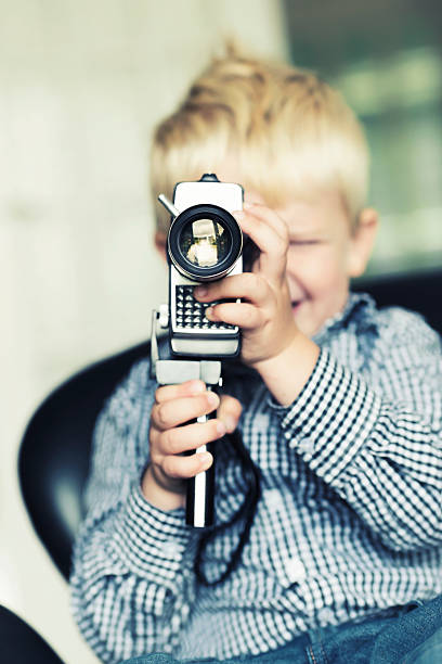 istock Boy shoots a video with an old retro camera 174810574