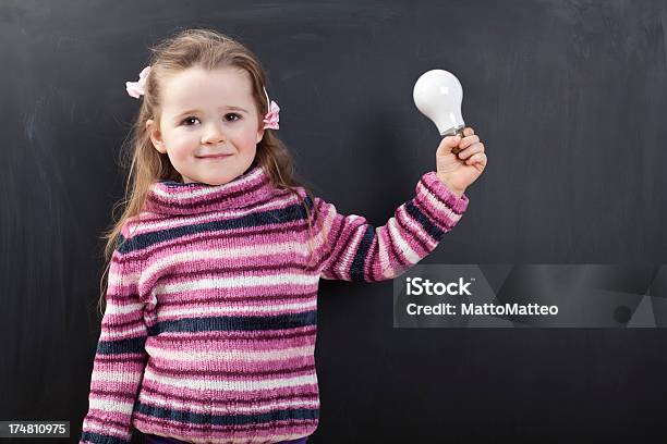 Photo libre de droit de Jolie Fille Devant Un Tableau banque d'images et plus d'images libres de droit de Ampoule électrique - Ampoule électrique, Apprentissage, Beauté