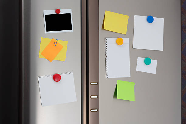 Note and polaroid on Refrigerator Door Photo of a blank sheet note paper and polaroid fastened to the front of a stainless steel refrigerator  adhesive note photos stock pictures, royalty-free photos & images